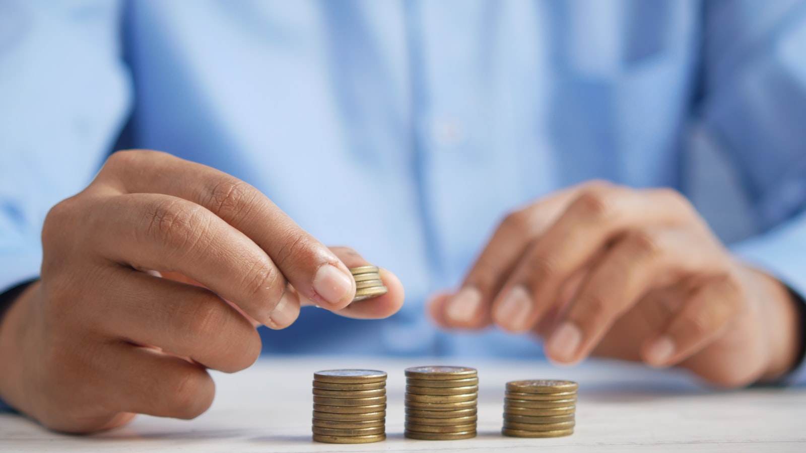 Tài Khoản Cent Exness Là Gì? Đặc Điểm, Ưu Nhược Điểm 2026 2 Người đang đếm và xếp các đồng xu nhỏ thành cột, minh họa mức backcom nhỏ tương ứng với giá trị cent lot